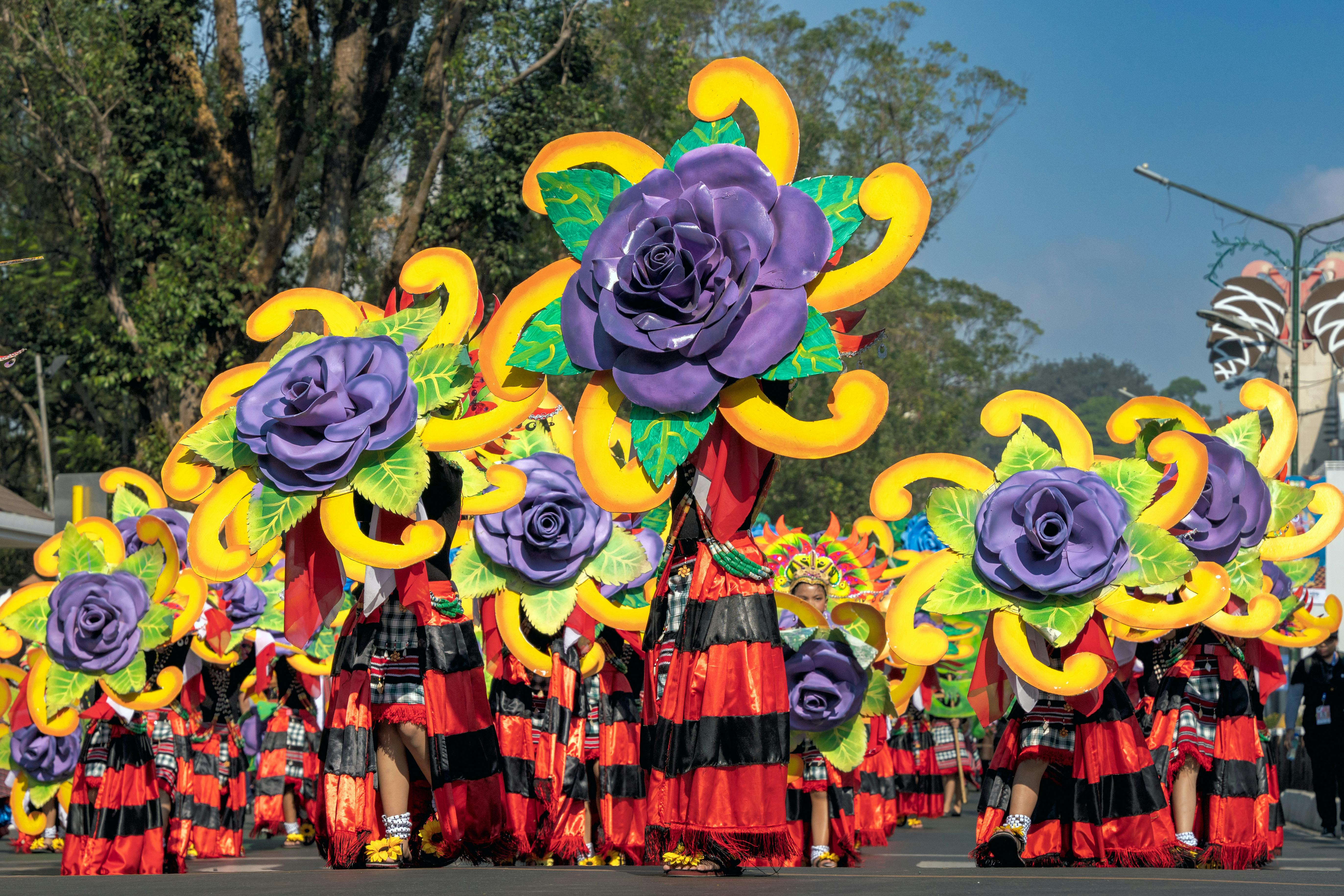 Colorful flower floats and dancers in traditional filipino attire at Baguio's Panagbenga Festival parade